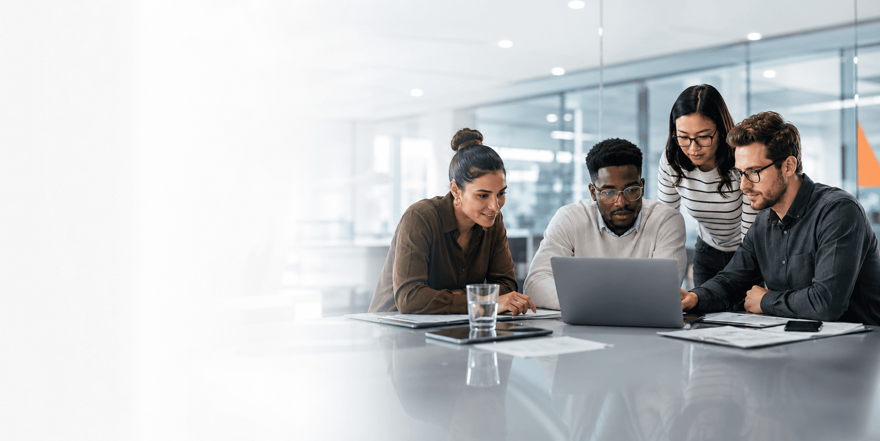 Firexus team collaborating around a laptop in a modern office